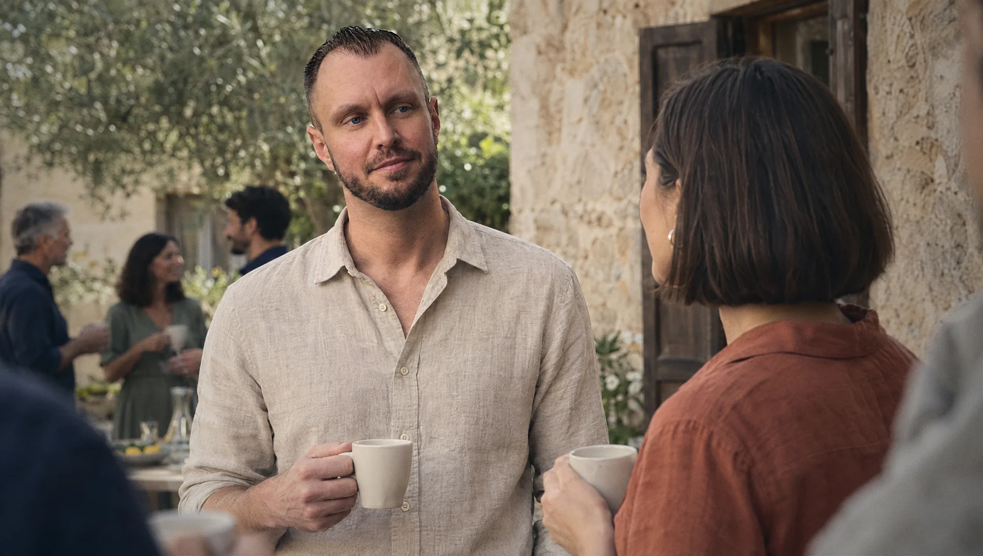 Michael Selck im Gespräch mit einer Unternehmerin in der Kaffeepause vor der Natursteinmauer der Finca — Abstand vom Tagesgeschäft